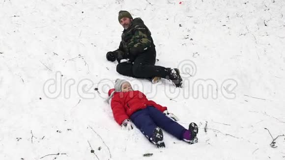 一个缓慢的动作视频父亲和女儿一起在雪地上玩高清视频的预览图