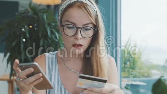 美女用信用卡和手机付款网上银行与智能手机视频的预览图