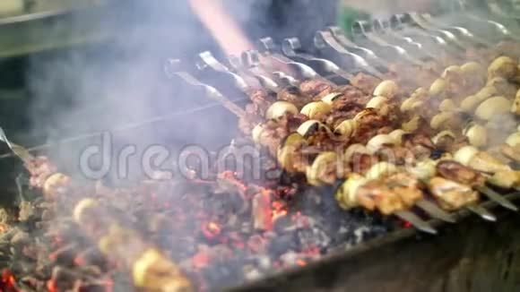 烤串烹饪在金属串上关闭烤肉时烤熟的肉用木炭和火焰烧烤野餐视频的预览图
