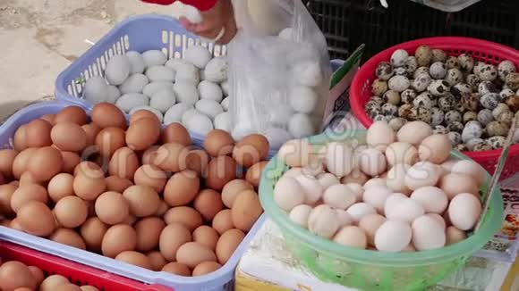 女性手选择一个白鸡蛋放在当地市场的塑料袋里视频的预览图