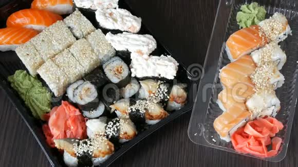 两套大寿司有很多寿司卷肉卷黑吉里甘坎黑色木桌上的时尚寿司视频的预览图