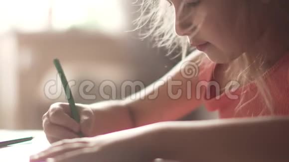毛茸茸的小女孩用蜡笔画画清晨阳光下的小女孩视频的预览图