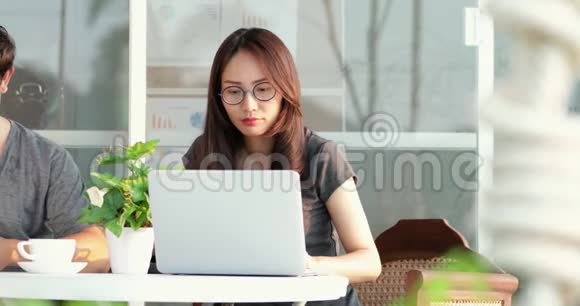 快乐的亚洲男人和女友一起使用手机和笔记本电脑视频的预览图