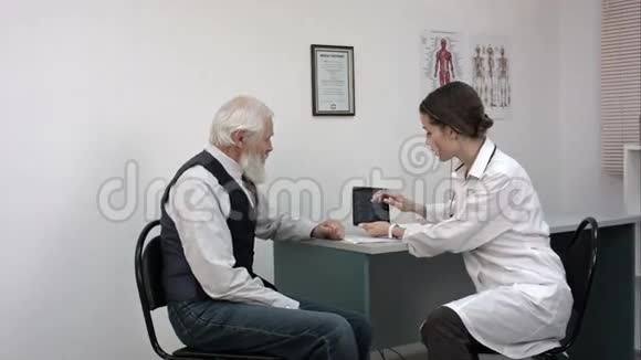 女性医生在一片有成熟患者的平板上检查x光视频的预览图