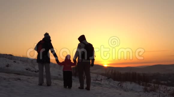 一个幸福的家庭有三个人在冬天站在山上视频的预览图