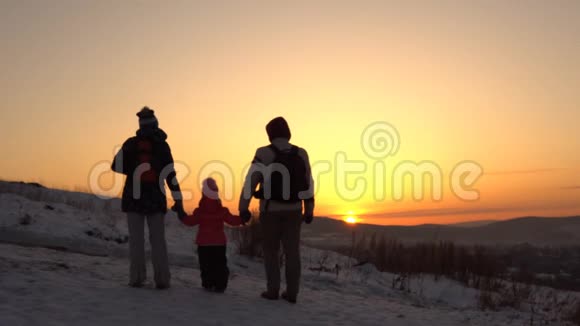 一个幸福的家庭有三个人在冬天站在山上视频的预览图