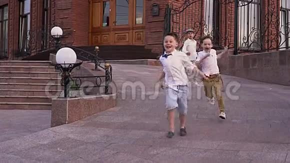 亲爱的友好的孩子们在街上玩耍穿白衬衫的男孩在街上奔跑视频的预览图