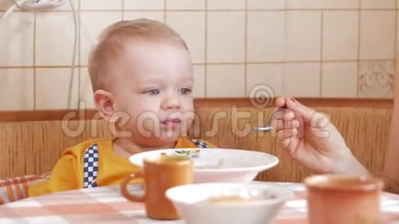宝宝2岁用勺子吃粥妈妈坐在男孩旁边家用家具视频的预览图