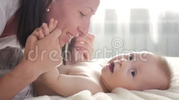 一位年轻快乐的母亲和她的小儿子在床上休息生育观念为人父母母亲美丽视频的预览图