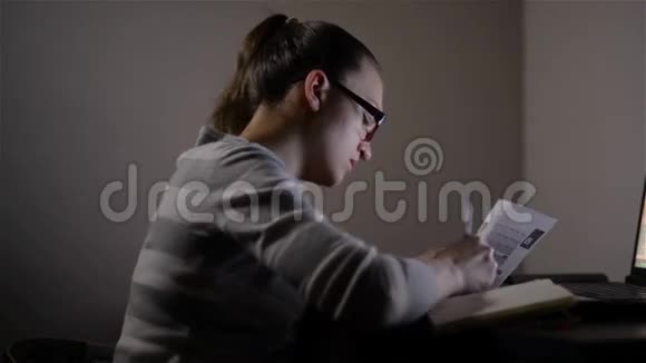 在家工作的年轻女性她工作到深夜美丽的女孩在晚上学习视频的预览图