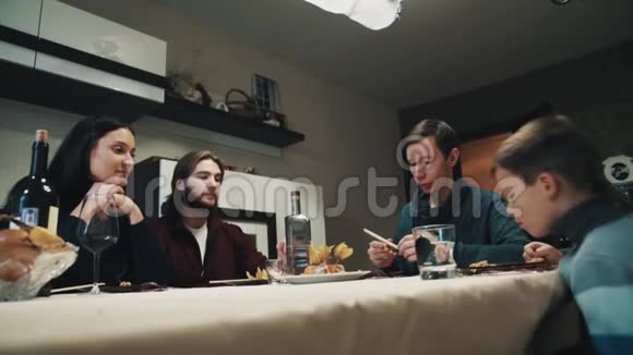 餐桌上的家人和朋友喝伏特加吃寿司庆祝视频的预览图