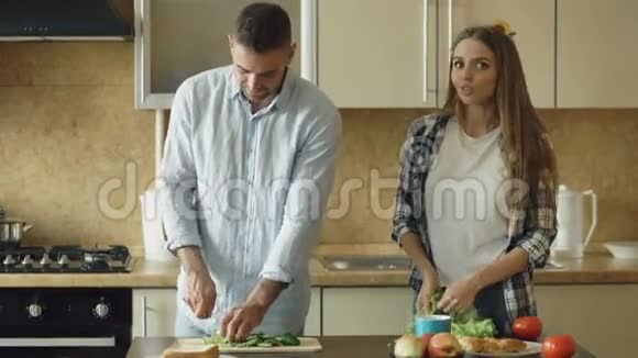 快乐的年轻夫妇一起在厨房做早餐视频的预览图