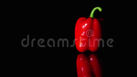 成熟的红辣椒在黑色背景上旋转特写慢动作光的运动改变照明视频的预览图