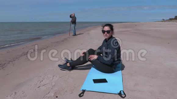 坐在海边健身垫上的女人视频的预览图