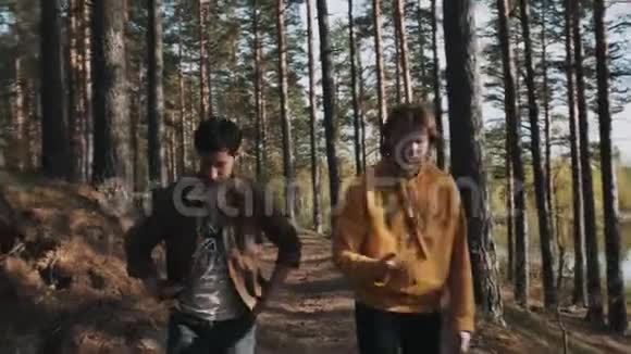 在森林里和朋友散步时男人拿起鹅卵石扔进湖里视频的预览图