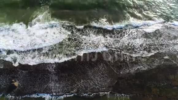 从海面的顶部可以看到在斯里兰卡的岩石悬崖上破碎的海浪视频的预览图