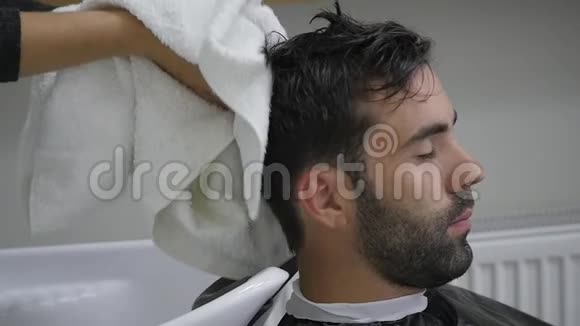 大胡子的年轻人用毛巾擦头美容师视频的预览图