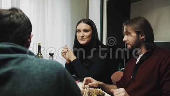 男人和女人在餐桌上和朋友聊天时嚼东西视频的预览图