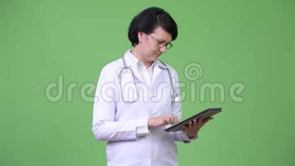 一位留着短发的漂亮女医生使用数码平板电脑视频的预览图