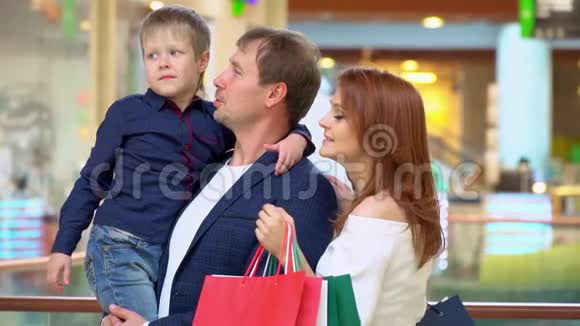 父母在贸易商场和儿子说话这家人在购物中心为圣诞节买东西圣诞节视频的预览图