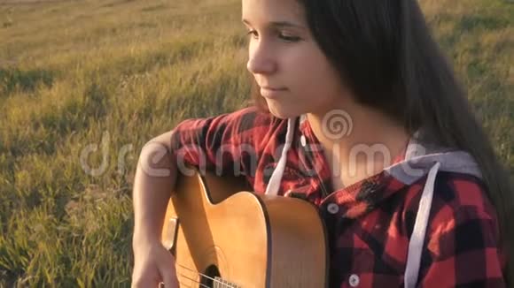 日落时分少女在草地上弹吉他视频的预览图