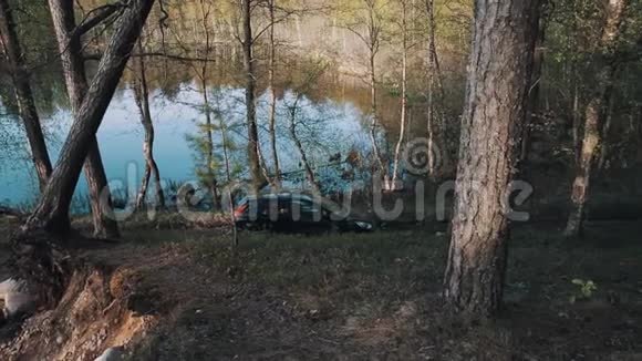 人类走出停在森林里的汽车停在湖边的大自然中视频的预览图