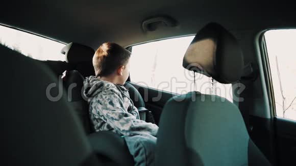 小男孩从汽车里爬出来的童椅视频的预览图
