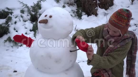 一个冬天的孩子在公园里堆雪人视频的预览图