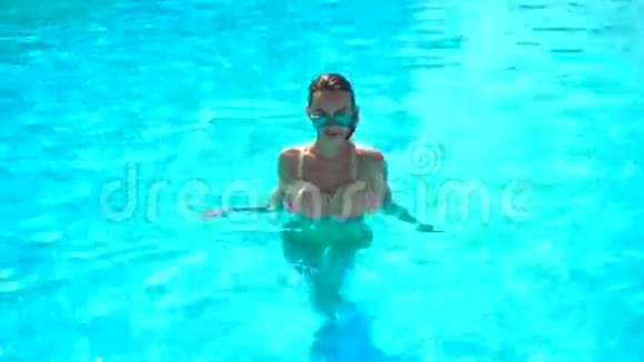 穿着湿头发和眼镜的泳衣的年轻女孩从游泳池里出来视频的预览图