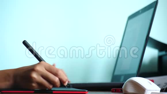 特写镜头女孩画在一个图形平板上自由职业一只手拿着笔在红色的黑色平板上移动4k慢动作视频的预览图