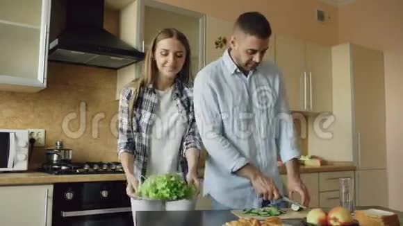 快乐的年轻夫妇一起在厨房做早餐视频的预览图