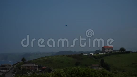 Paraplane在乡间海边的青山上飞翔视频的预览图