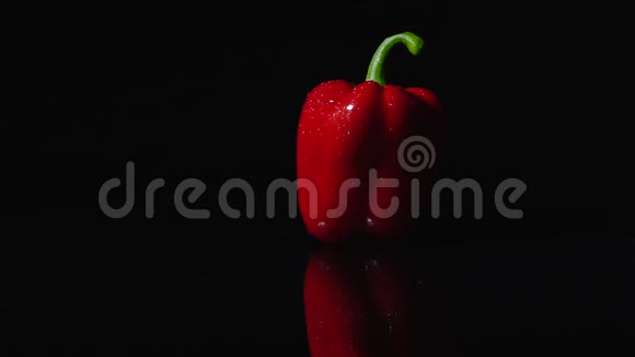 成熟的红辣椒在黑色背景上旋转特写慢动作光的运动改变照明视频的预览图