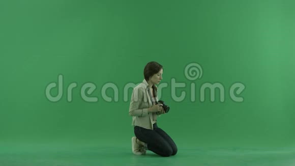 坐着的年轻女子正在绿色屏幕上右手边拍宏观照片视频的预览图
