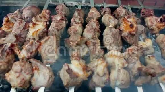 用木炭烤肉男人在金属串上做开胃的烤羊肉串有皮的美味肉块烧烤视频的预览图