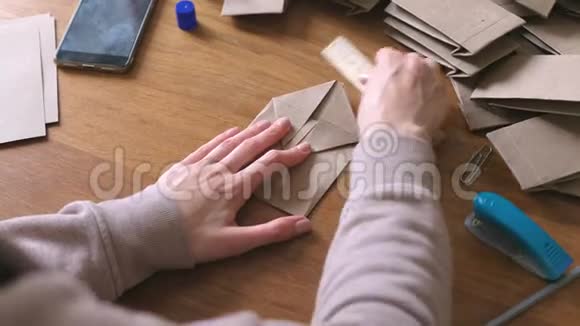 女人用牛皮纸做纸袋双手特写视频的预览图