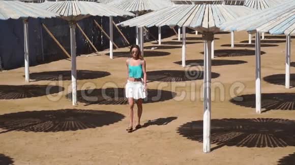 穿裙子戴眼镜的女孩在海滩平房之间视频的预览图