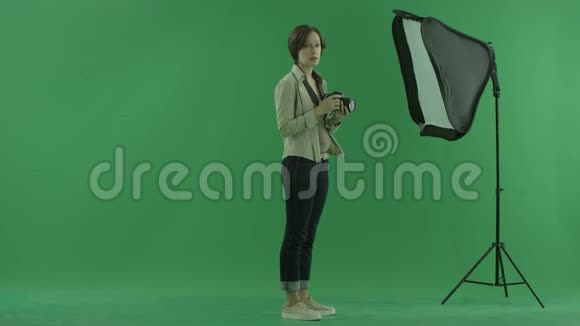 一位年轻女子正试图在绿色屏幕的右手边使用视频的预览图