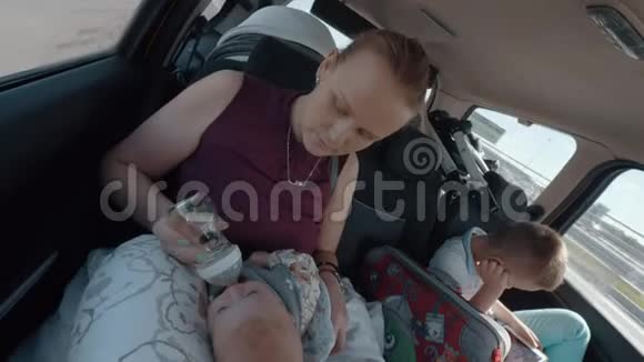 有宝宝和大儿子的女人开车旅行视频的预览图