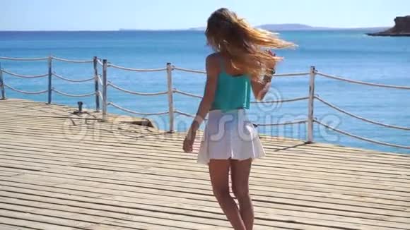 穿裙子的女孩长发在海上缓慢地沿着码头奔跑视频的预览图