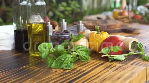 木质厨房桌子上的蔬菜背景特写新鲜蔬菜罗勒草橄榄油调味用视频的预览图