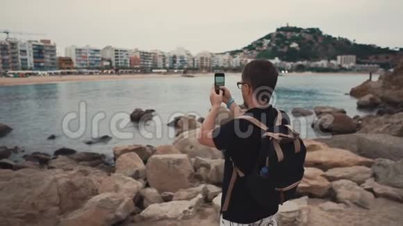 游客在岸上拍海的照片视频的预览图