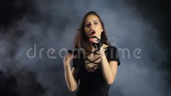 女孩唱摇滚歌曲她精力充沛性感黑烟背景视频的预览图