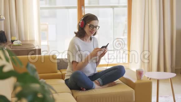 在沙发上享受音乐的女人视频的预览图