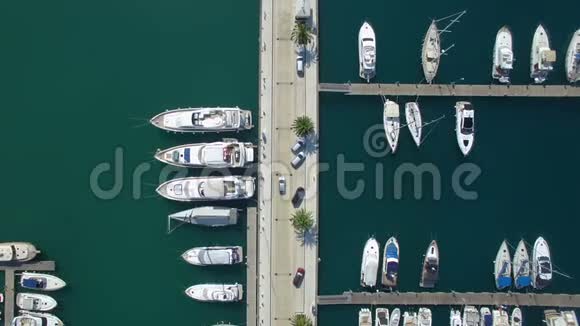 从顶部可以看到黑山港码头的空中镜头该码头的汽车在豪华游艇和帆船之间行驶视频的预览图