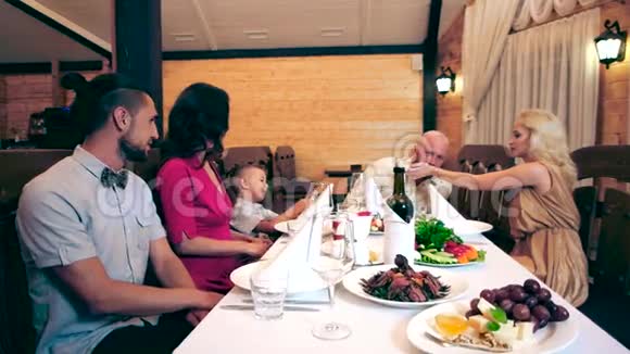 一家人聚集在餐馆里一大群朋友在咖啡馆吃晚饭一个孩子和他的父母在家里视频的预览图