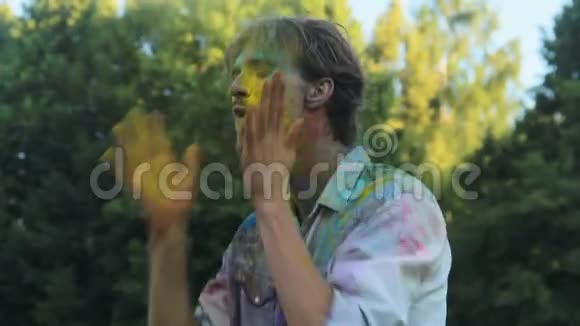 年轻男子浑身涂着彩色颜料跳舞在霍利节上玩得开心视频的预览图