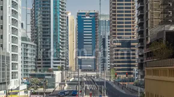 迪拜码头伴随着摩天大楼的时间推移和穿过运河的混凝土路桥附近的街道上的交通视频的预览图