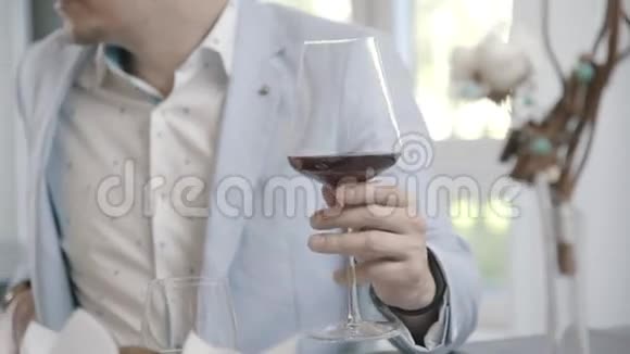 一杯红酒在男人手餐厅的概念晚会视频的预览图