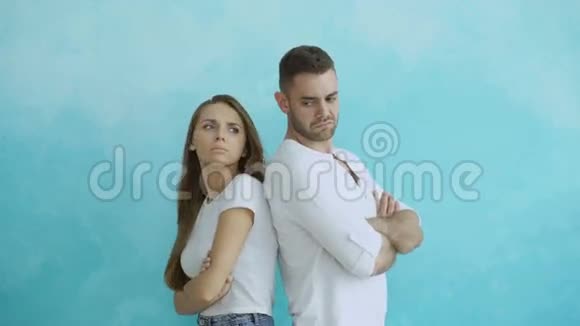 年轻夫妇在蓝色背景下站在后面生气视频的预览图